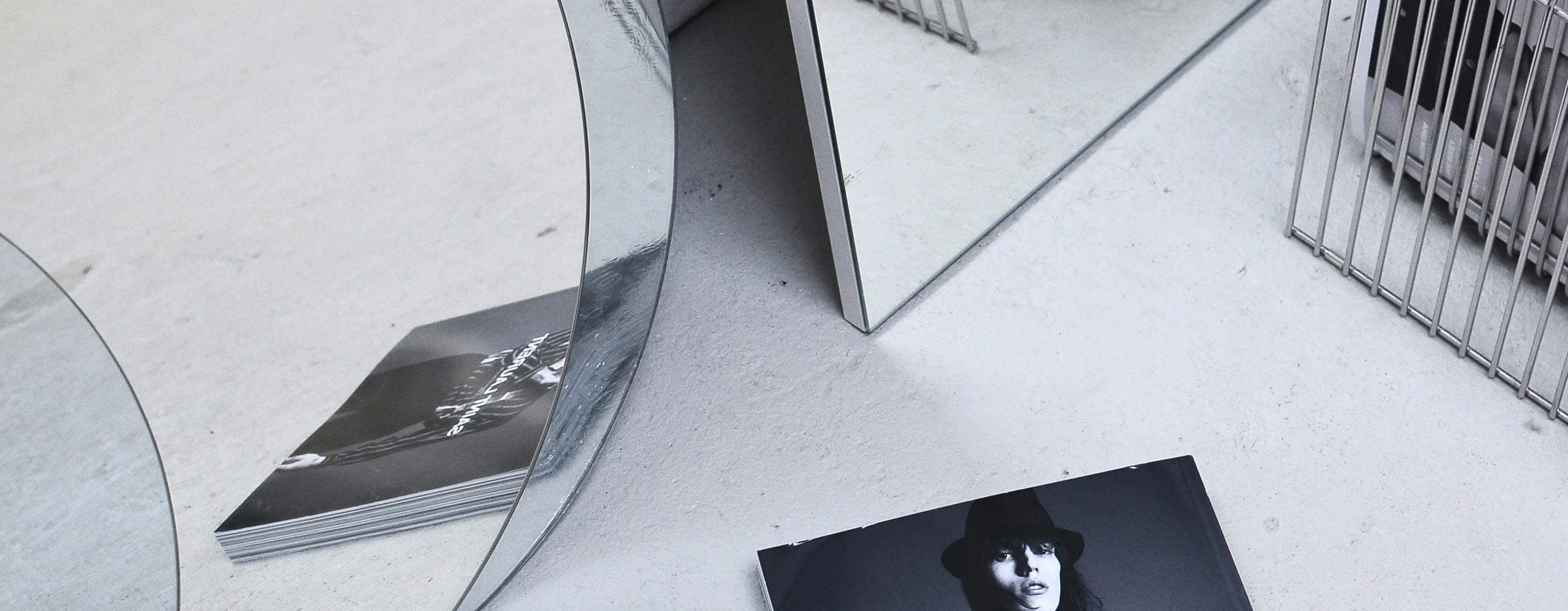 Book with a cover featuring a person wearing a Saint Laurent outfit on a white surface.
