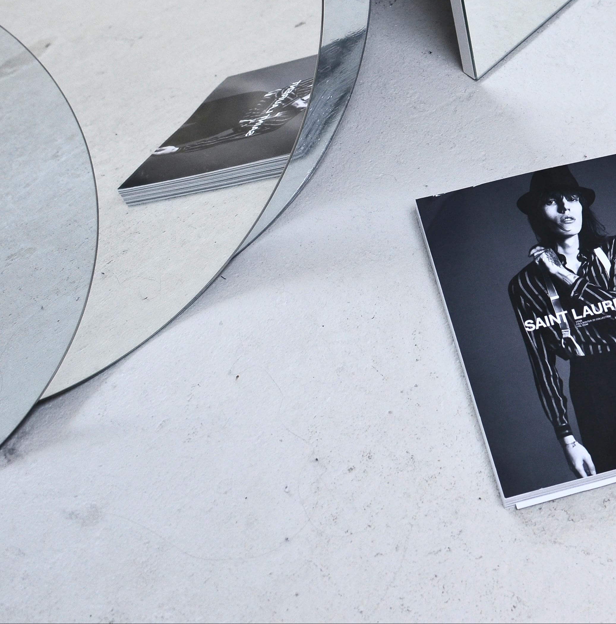 Book with a cover featuring a person wearing a Saint Laurent outfit on a white surface.